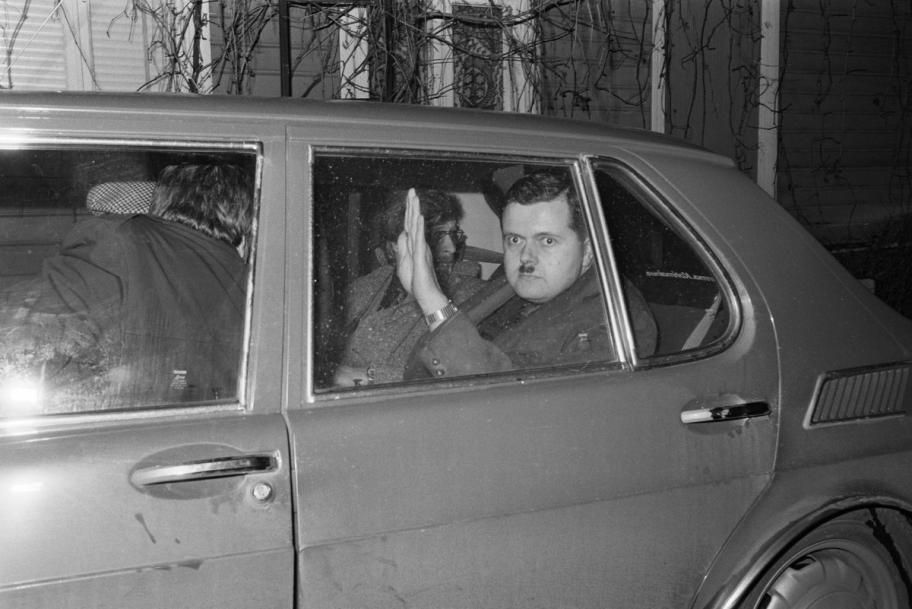 Pekka Siitoin nostaa kättään tervehdykseen auton takapenkillä.