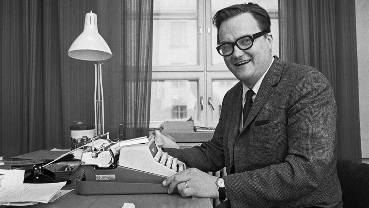 Mustavalkoinen kuva, jossa Erik Allardt istuu kirjoituskoneen ääressä.