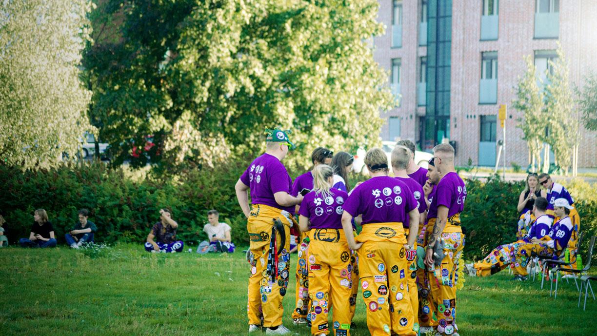 Opiskelijoita haalareissa pihalla.