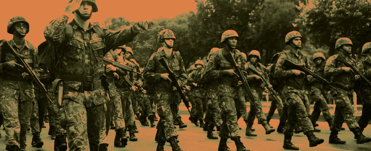 Maastonvihreäksi ja oranssiksi väritetty valokuva sotilaista, jotka marssivat joukkona taisteluasuissa, kypärät päässä ja aseet kädessä. 