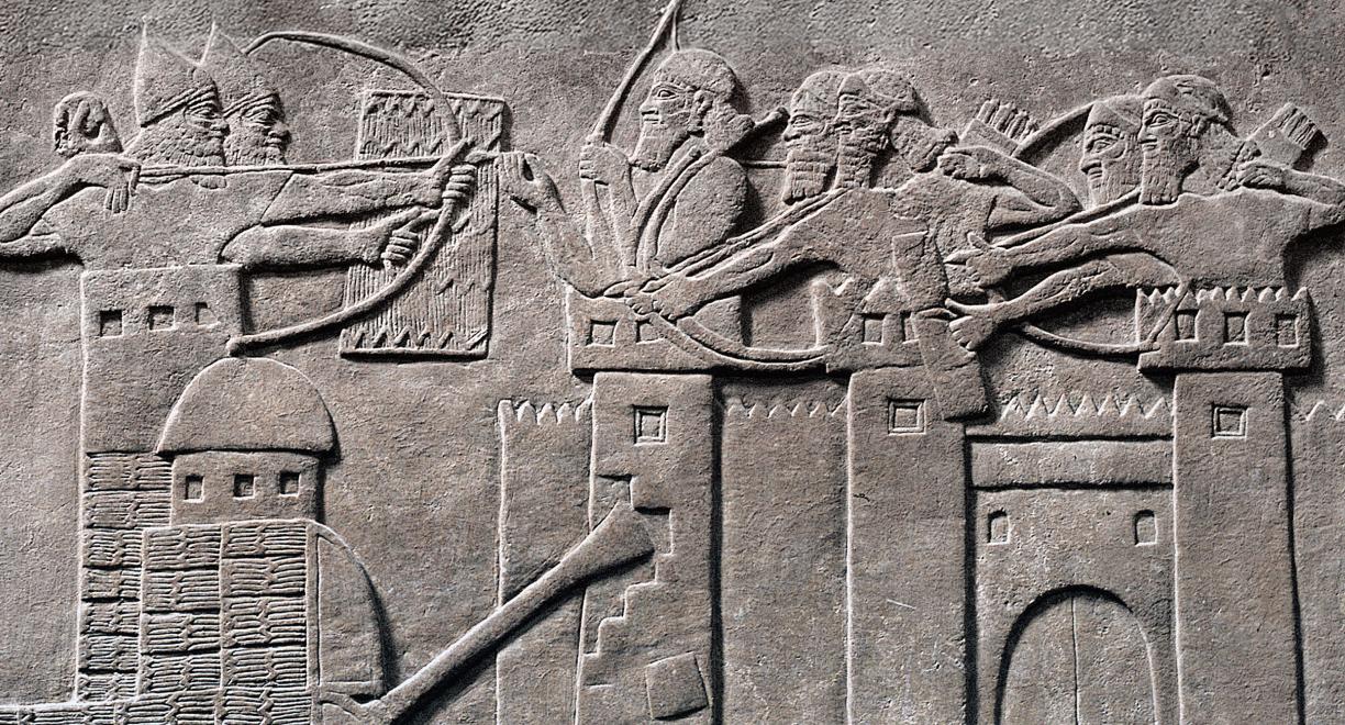 Kivireliefi, johon on hakattu tyylitelty kuva taistelusta. Jonkinlainen suuri liikuteltava hyökkäysvaunu murtaa suurta kaupunginmuuria. Sekä vaunun yläosassa että kaupunginmuurin päällä on sotilaita, jotka ampuvat toisiaan jousilla.