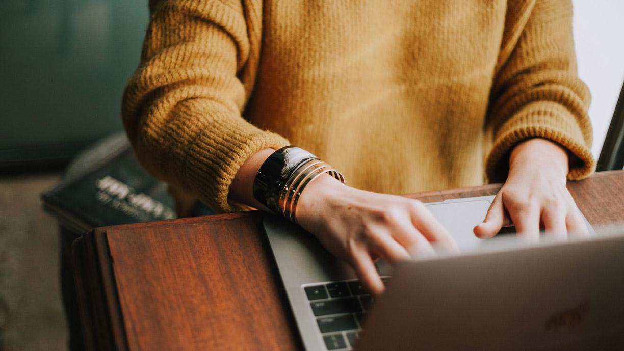 Ihminen, joka käyttää kannettavaa tietokonetta.