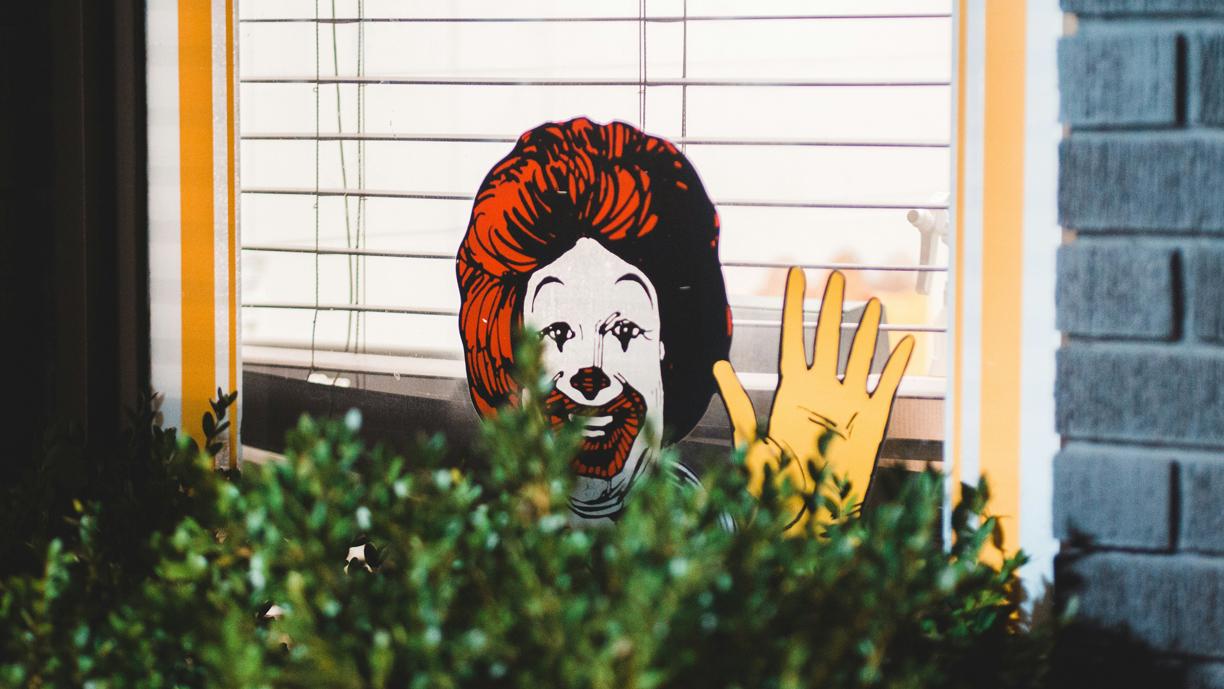 Piirretty Ronald McDonald -hahmo heiluttaa ikkunassa.