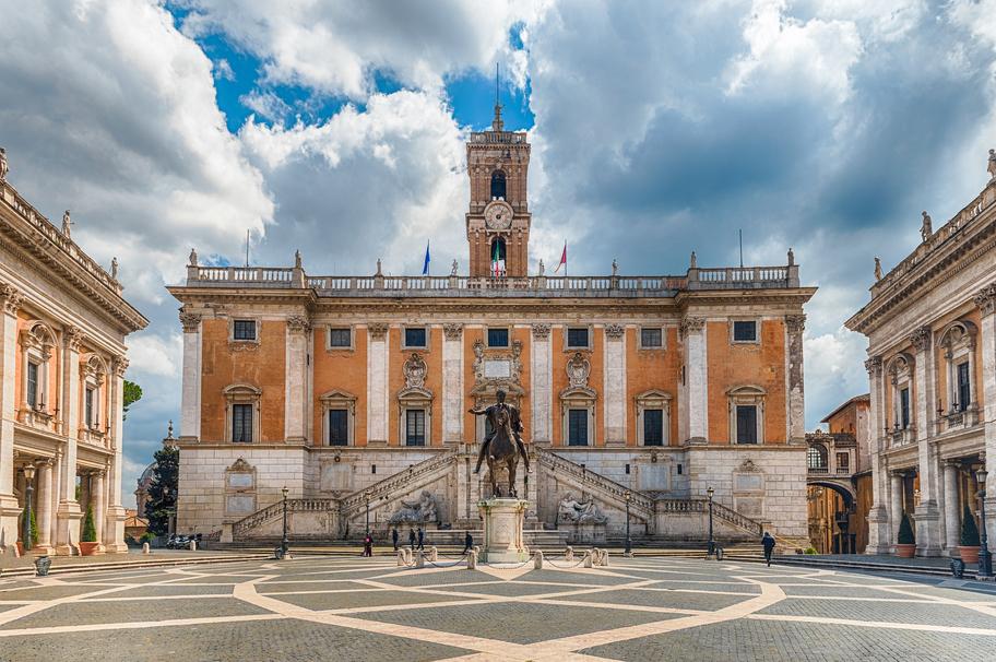 Piazza del Campidoglio -aukio Roomassa, jonka keskellä on patsas ja laidoilla vanhoja rakennuksia. Kivetyksessä on symmetrinen kuvio.