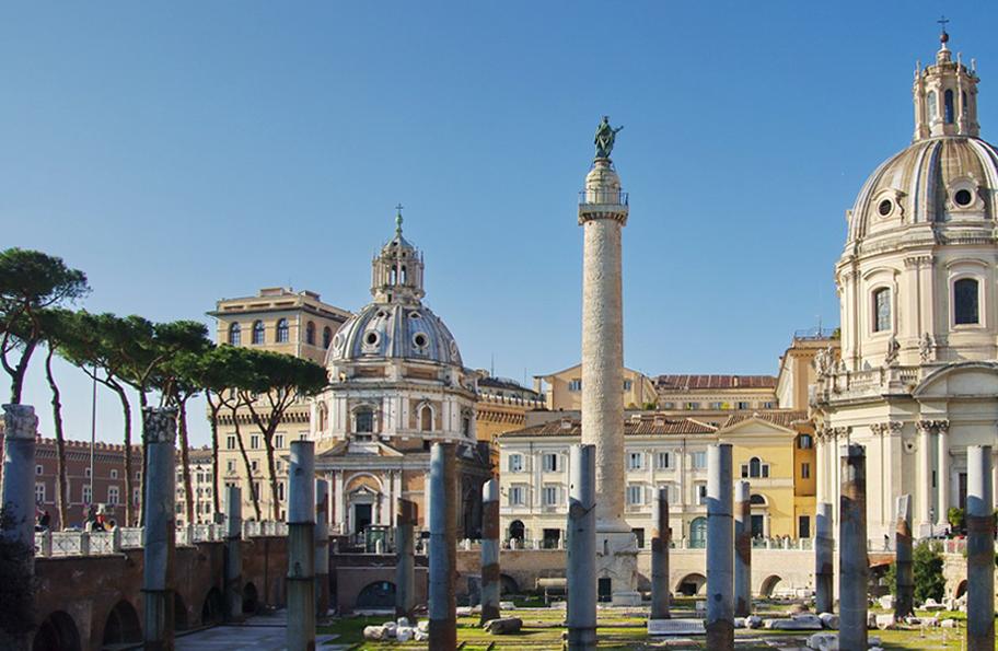 Roomalainen aukio, jonka reunoilla on kirkkoja ja muita suuria rakennuksia. Aukiolla kohoaa vaaleasta kivestä tehty korkea pylväs.