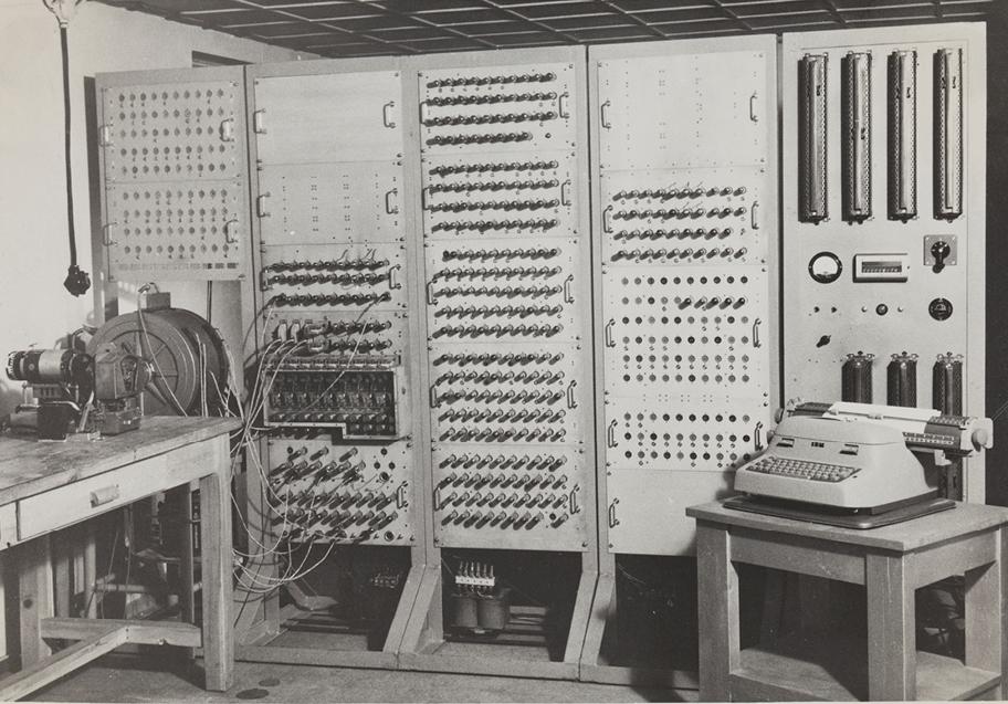 Mustavalkoinen valokuva teknisestä laitteesta, jossa on viisi huoneen korkuista paneelia.