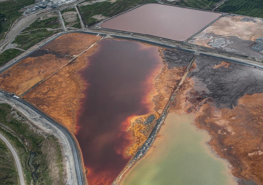 Suuria vesialtaita maastossa ilmasta kuvattuina. Vesi on enimmäkseen väriltään punaruskeaa, paikoin lähes mustaa ja yhdessä kohdassa samean vihreää.