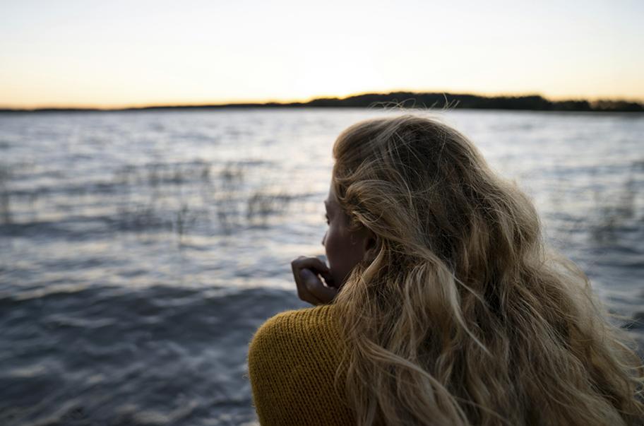 Maisema, jossa henkilö katselee järvelle.